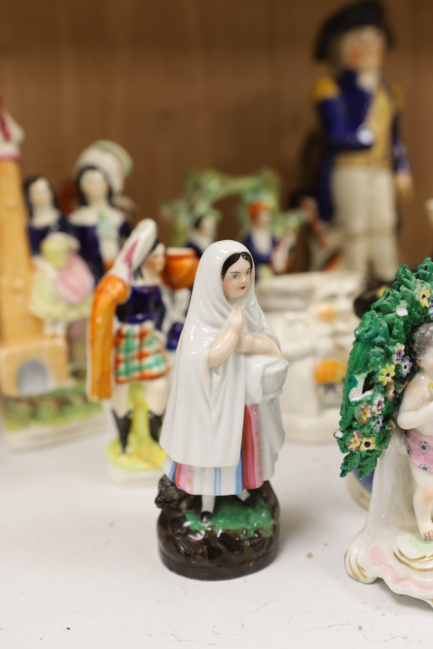 A large group of Staffordshire pottery figures and groups and figural cruets, to include a Nelson commemorative Toby jug, 31 cms high.